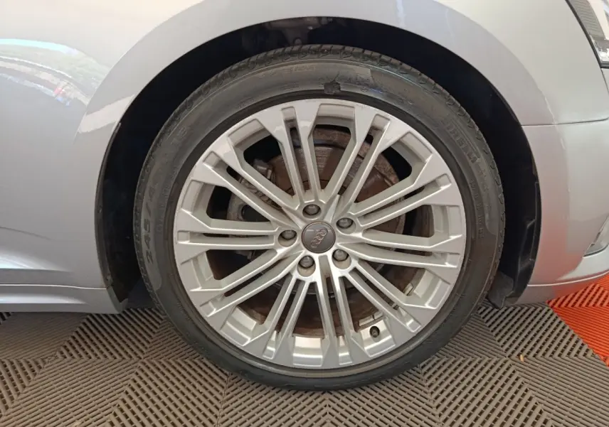Gros plan sur la roue avant droite gris clair d'une Audi A5 40 TFSI 2019 avec jante alliage multi-branches.