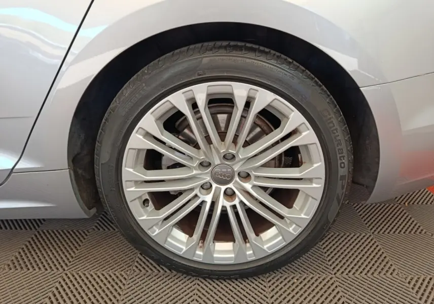 Gros plan sur la roue arrière droite gris clair d'une Audi A5 40 TFSI avec jante alliage multi-branches.