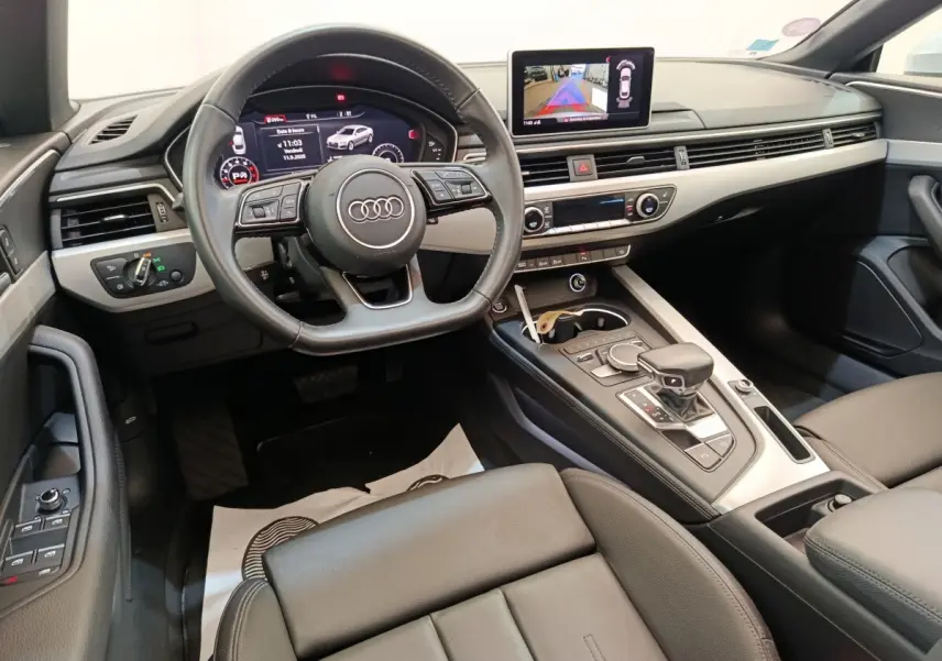 Vue intérieure de l'Audi A5 40 TFSI 2019, tableau de bord moderne avec écran multimédia et volant cuir noir.