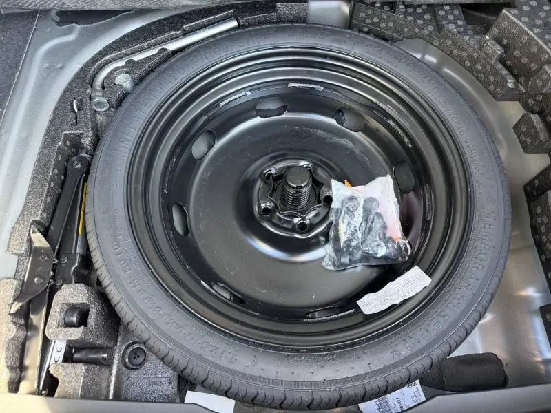 Vue rapprochée de la roue de secours noire dans le coffre d'une CUPRA Formentor 1.5 eTSI Hybrid 2025.