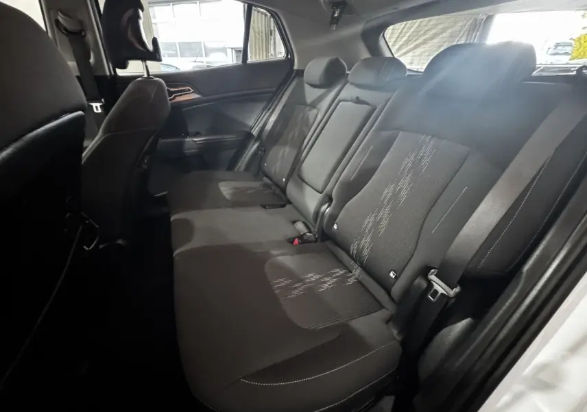 Vue intérieure côté droit des sièges arrière noirs du Kia Sportage 2024 avec ceinture de sécurité visible.