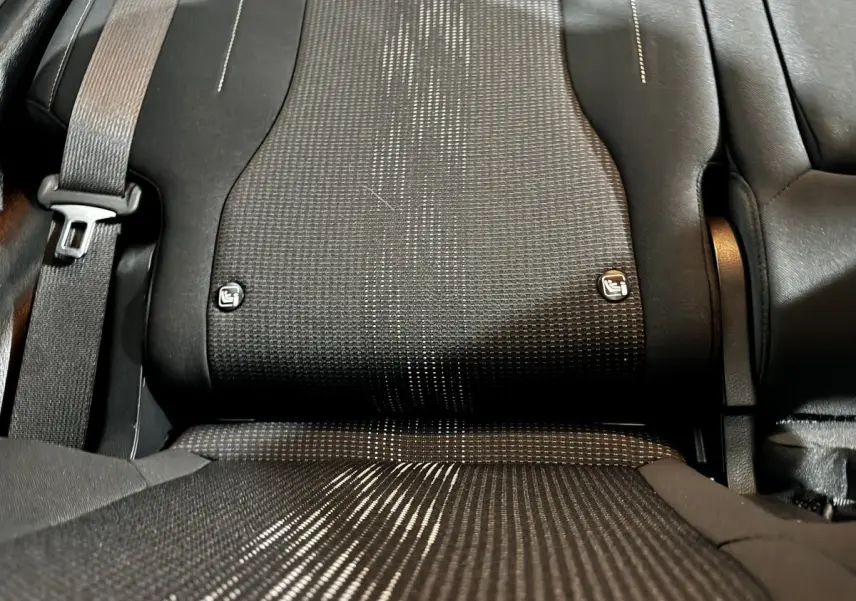 Gros plan sur la banquette arrière noire du Kia Sportage 2024, avec ceintures et fixations Isofix visibles.