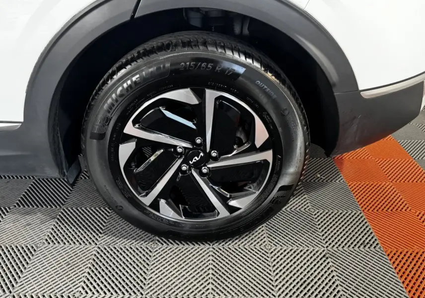 Gros plan sur la roue arrière droite du KIA Sportage blanc 2024 avec jante alliage bicolore et pneu Michelin.