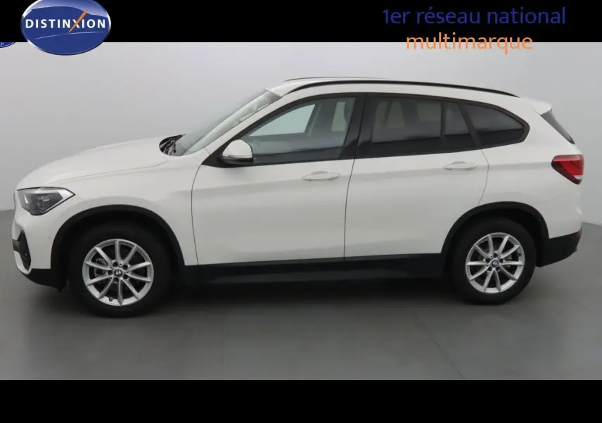 Profil côté gauche d'un BMW X1 blanc Alpine Metal 2022 avec jantes alliage et vitres teintées.