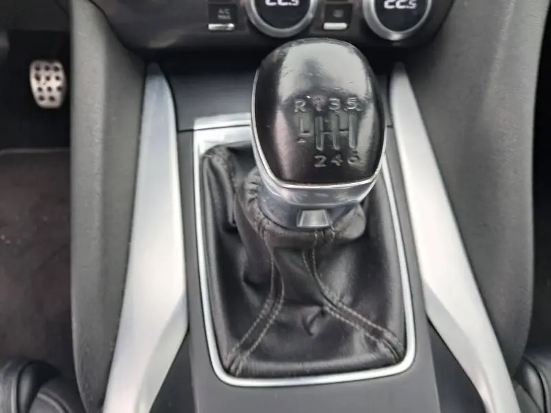 Le levier de vitesses manuel noir de la Citroën DS5 HDI 160 Sport Chic, entouré d'inserts argentés sur la console centrale.