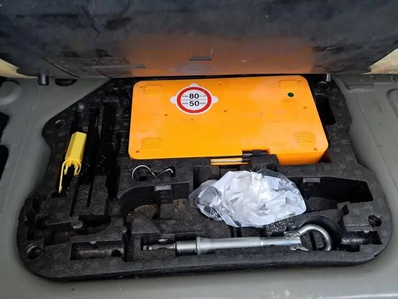 Coffret d’outils et kit de sécurité dans le coffre d’une Citroën DS5 gris foncé 2014, version HDI 160 Sport Chic.