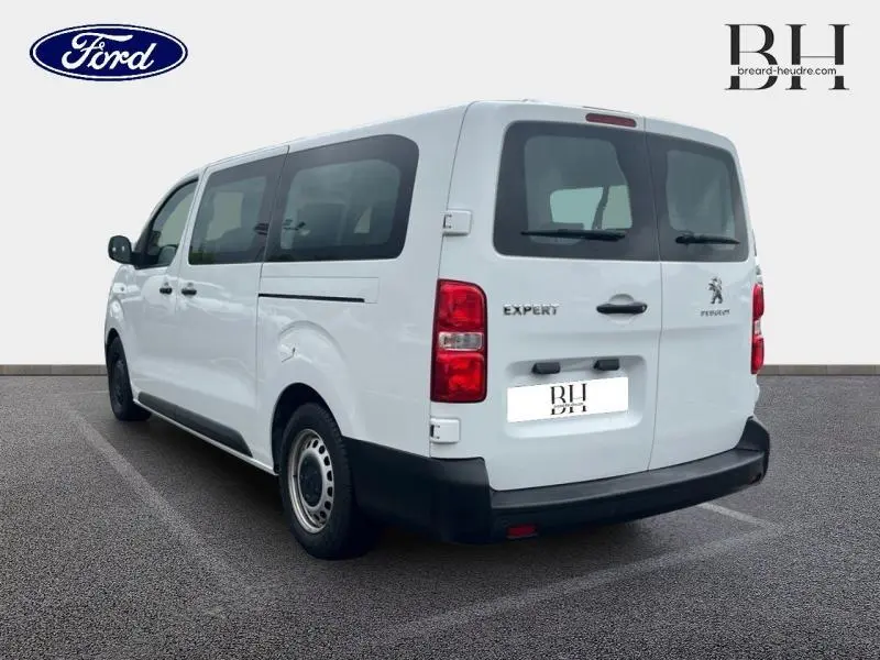 Vue 3/4 arrière droite d'un Peugeot Expert Fourgon blanc Banquise avec portes arrière battantes et vitres teintées.
