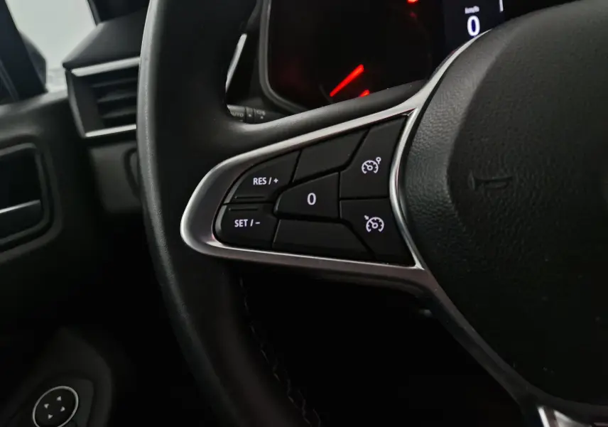 Gros plan sur les commandes de régulateur de vitesse au volant d'une Renault Clio V 1.0 TCE 90 Zen, intérieur noir.