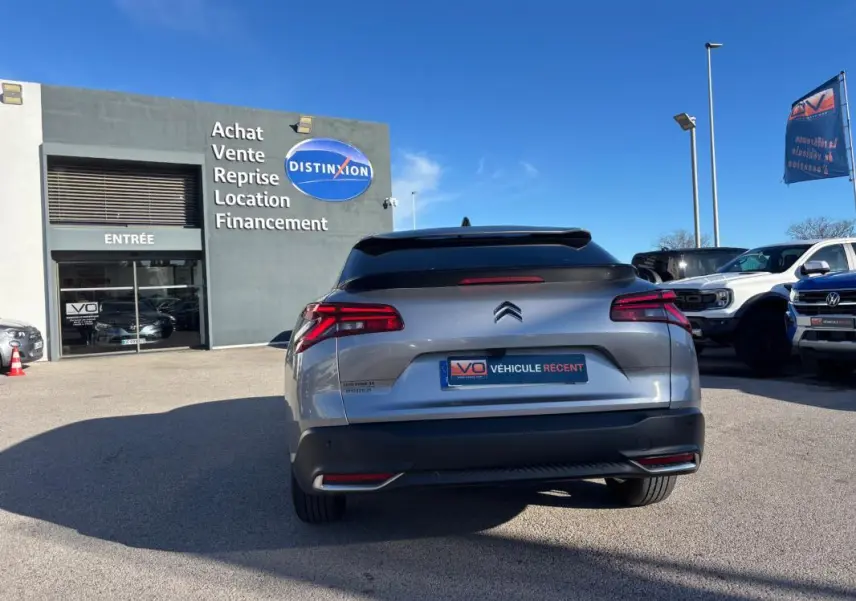 Vue arrière d'une Citroën C5 X gris foncé 2024 avec feux LED et jantes alliage 19 pouces, stationnée en extérieur.