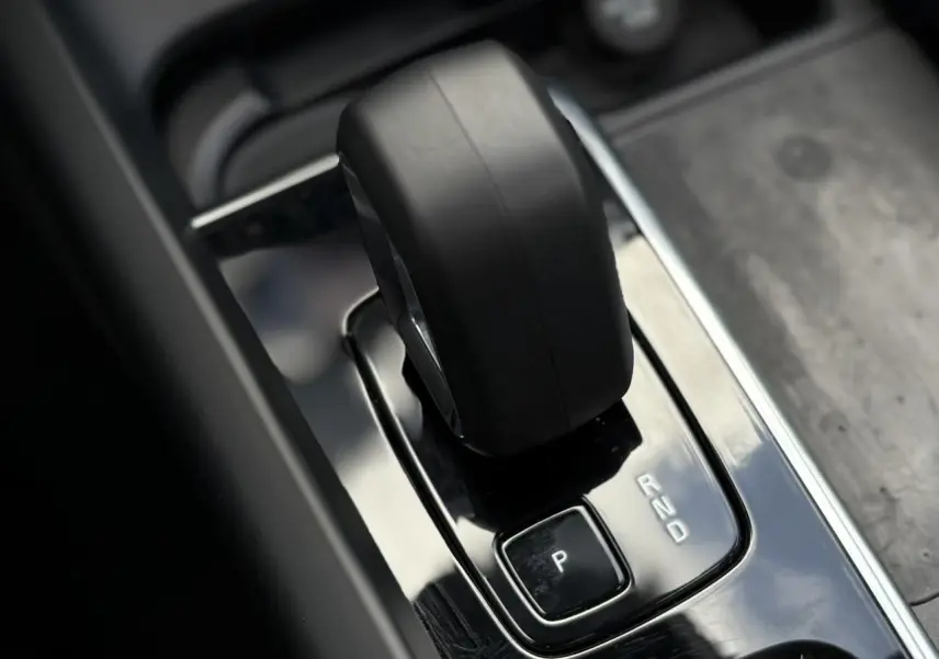 Gros plan sur le levier de vitesse automatique noir dans la console centrale brillante du Volvo XC60 gris silver.