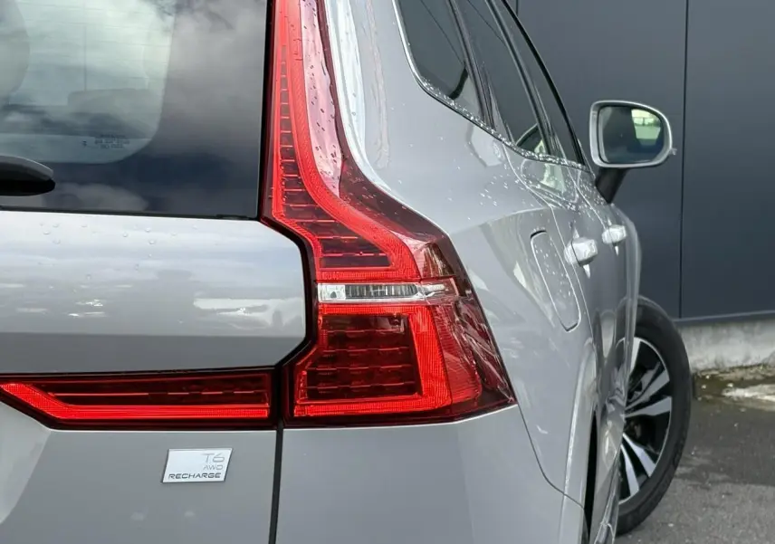 Vue arrière droite du Volvo XC60 T6 AWD PHEV gris silver, mettant en valeur les feux arrière LED et la jante alliage.