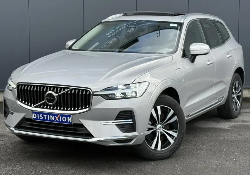 Volvo XC60 T6 AWD PHEV gris silver en 3/4 avant droit, avec calandre chromée et jantes alliage 18 pouces.