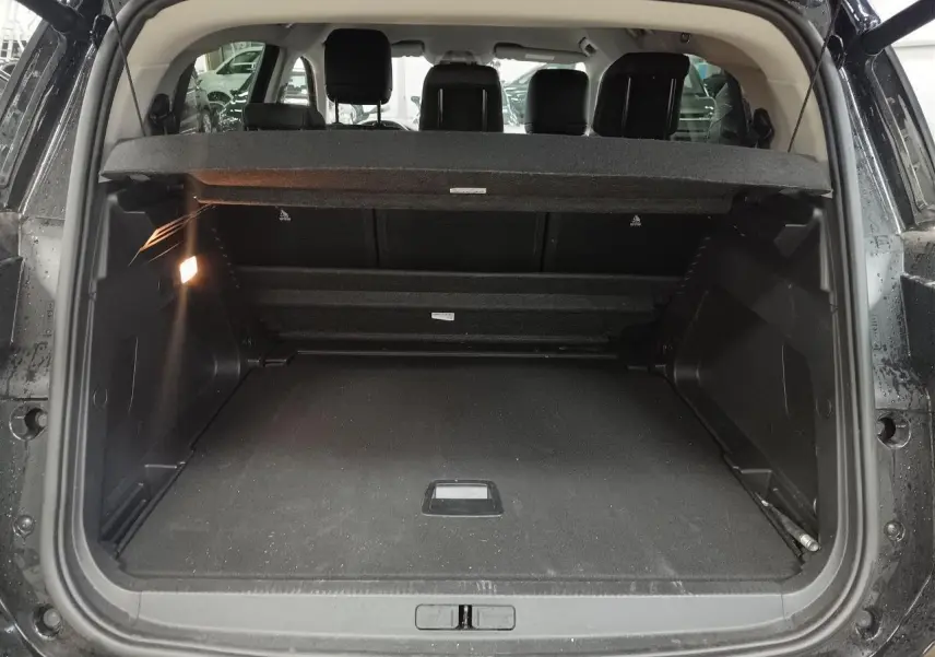 Coffre ouvert en vue arrière d’un Citroën C5 Aircross Hybrid noir Perla, montrant les sièges arrière et le hayon électrique.
