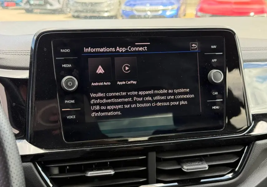 Écran tactile central du Volkswagen T-Roc 2025 affichant la fonction App-Connect, entouré de commandes noires brillantes.