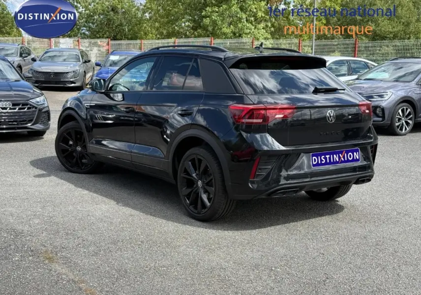 Volkswagen T-Roc noir nacré en 3/4 arrière droit, avec jantes noires et vitres arrière surteintées.