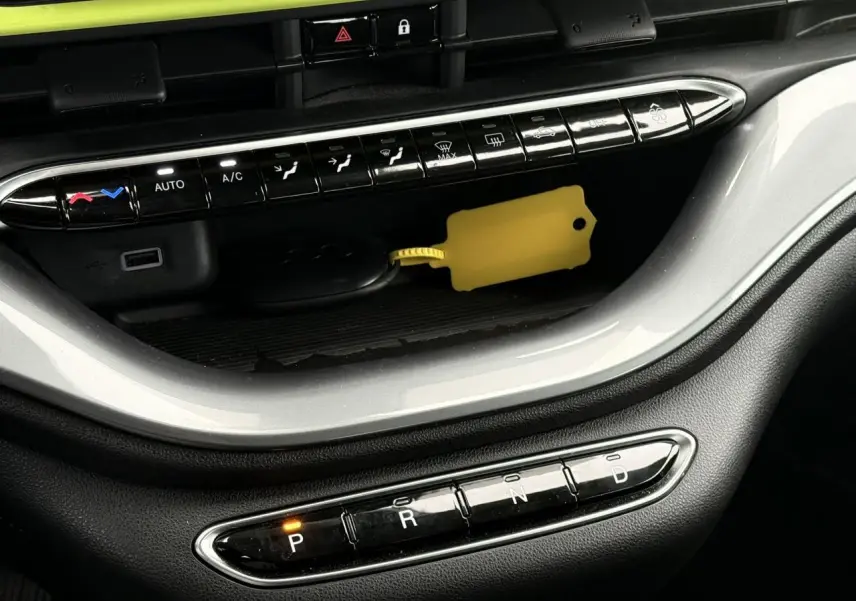 Gros plan sur la console centrale de la Fiat 500 électrique 2024, avec sélecteur de boîte auto et bouton "P" allumé.