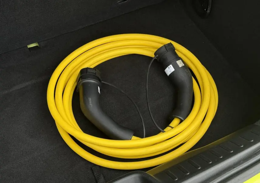 Câble de recharge électrique jaune enroulé dans le coffre d'une FIAT 500 Electrique Jaune Acid 2024.
