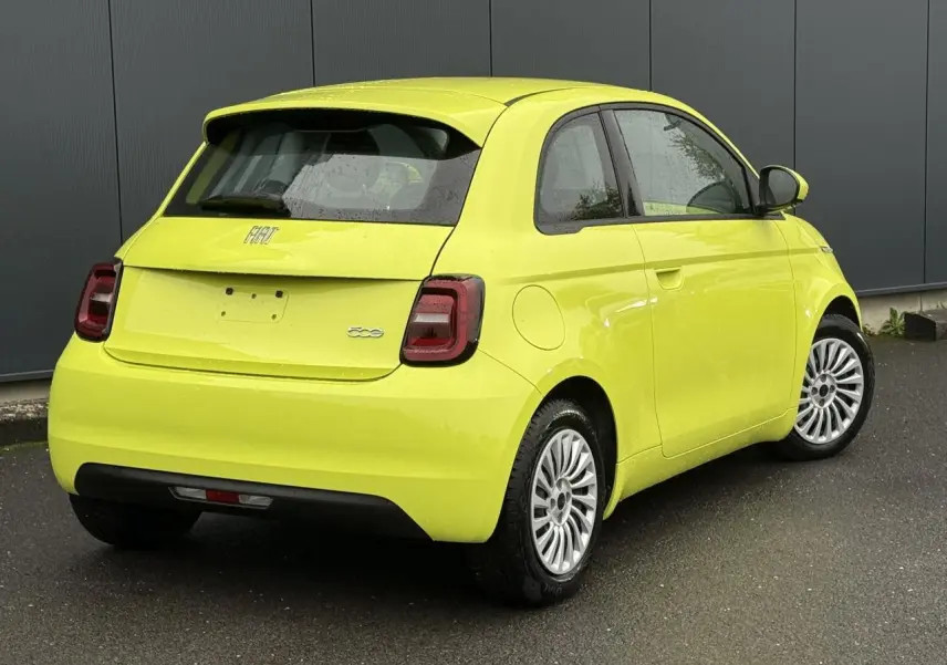 Vue 3/4 arrière droite d'une Fiat 500 électrique 2024 en jaune Acid avec feux arrière foncés et jantes multibranches.