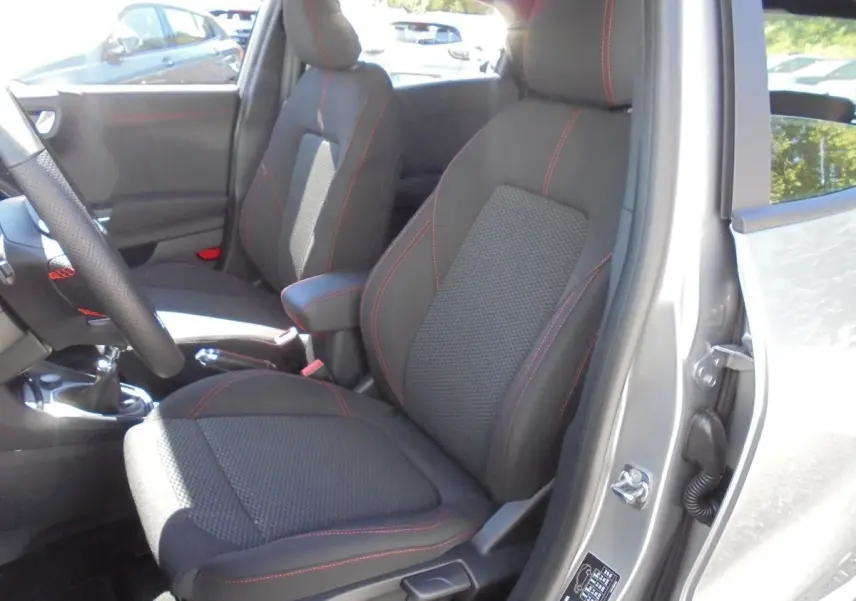 Intérieur du Ford Puma 2022 gris solar metal, vue côté conducteur sur sièges noirs avec surpiqûres rouges et boîte manuelle.