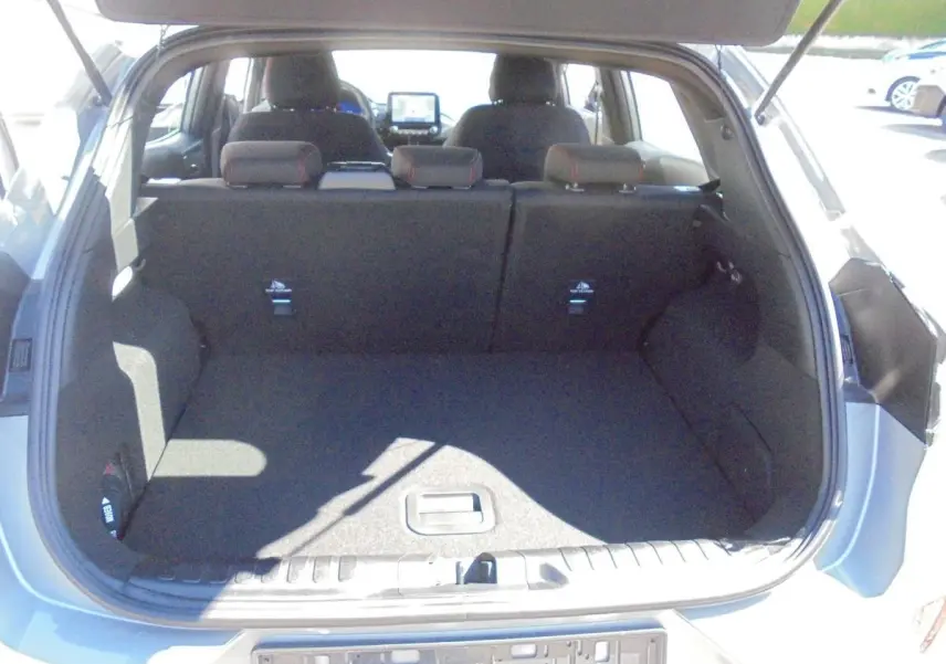 Coffre ouvert vu de l'arrière d'un Ford Puma gris Solar Metal, montrant l'espace de chargement et les sièges arrière.