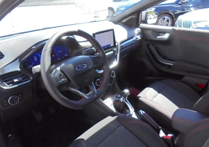 Intérieur avant droit du Ford Puma gris Solar Metal 2022, volant cuir perforé, tableau de bord digital et boîte manuelle.