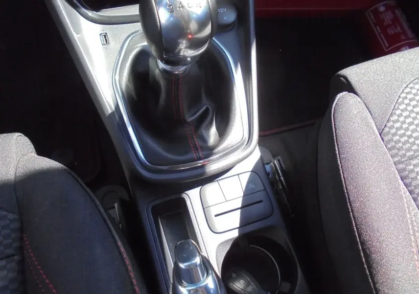 Vue rapprochée de la console centrale du Ford Puma gris Solar Metal 2022, mettant en valeur le levier de vitesse manuel et les sièges noirs.