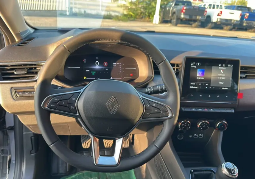 Vue intérieure centrée sur le volant Renault Clio 2025 avec tableau de bord numérique et écran tactile multimédia.