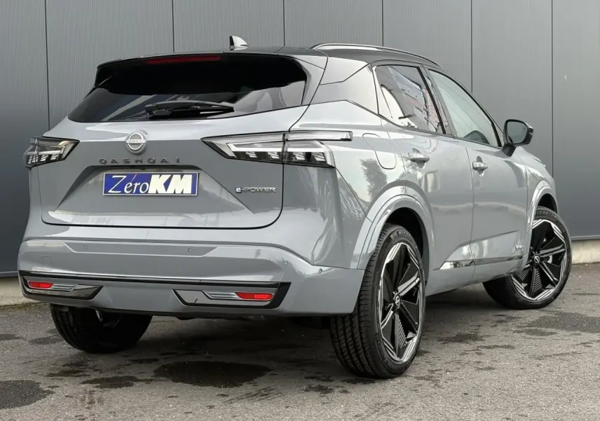 Vue 3/4 arrière droit du Nissan Qashqai 2025 gris Ceramic avec toit noir panoramique et jantes alliage 20 pouces.