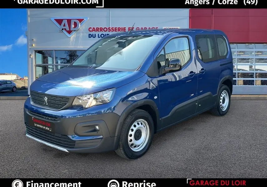 Vue 3/4 avant droit d'un Peugeot Rifter bleu 2024 avec jantes tôles et coques de rétroviseurs noires vernies.