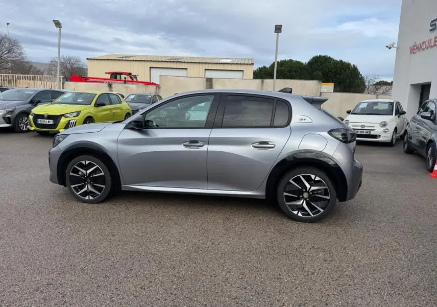 Peugeot 208 Hybrid 110 GT gris en vue profil droit, avec jantes alliage 17 pouces et toit noir contrasté.