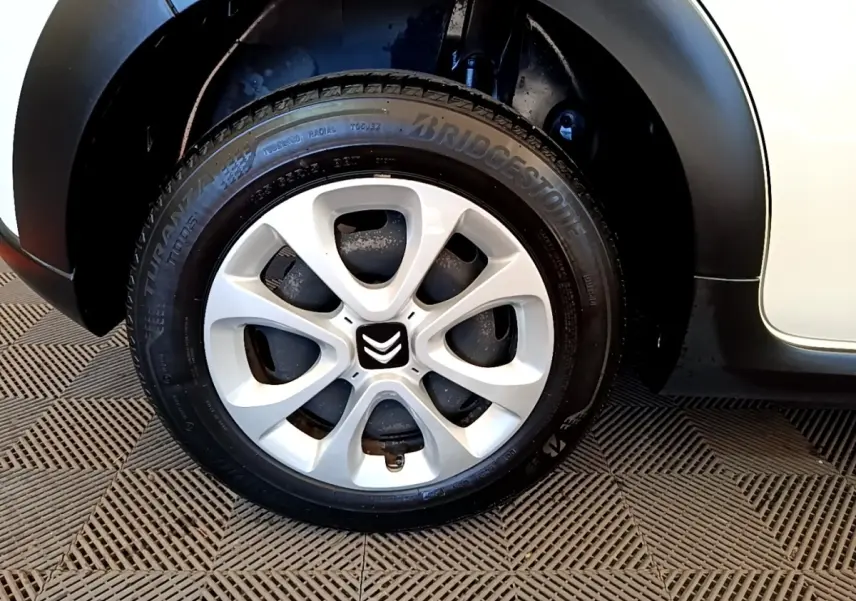 Gros plan sur la roue avant gauche blanche d'une Citroën C3 2022 avec jante en alliage et pneu Bridgestone.