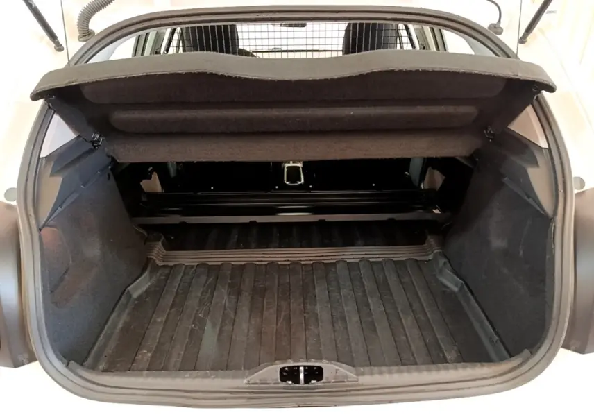 Vue arrière du coffre ouvert d'une Citroën C3 blanche, montrant l'espace de chargement et la tablette cache-bagages relevée.