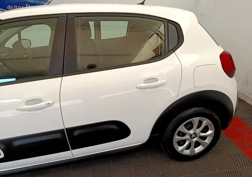 Vue latérale droite d'une Citroën C3 blanche avec protections noires sur les portières et jantes argentées.