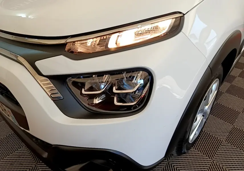 Gros plan sur l'avant droit blanc de la Citroën C3 2022 avec phares LED et détails noirs contrastants.