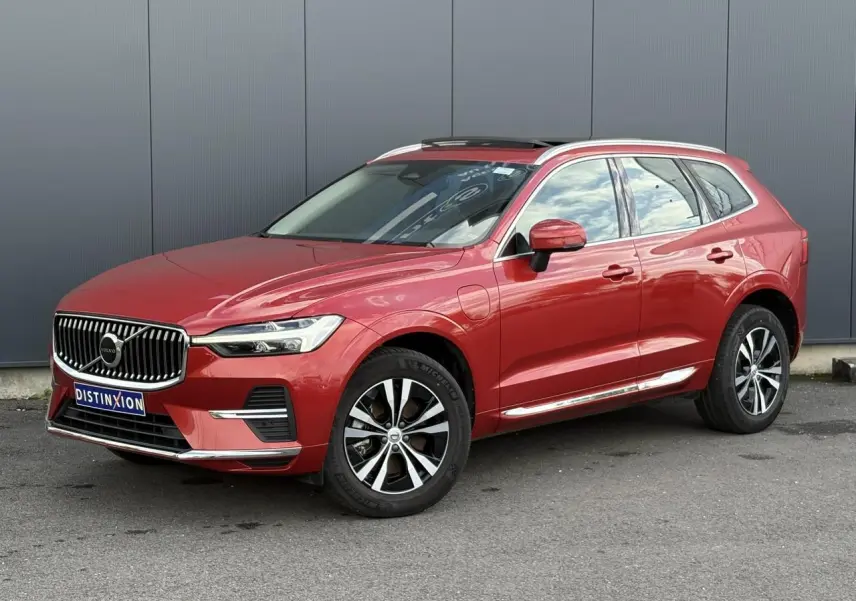 Volvo XC60 T6 AWD PHEV rouge Fusion en 3/4 avant droit, jantes alliage et toit ouvrant panoramique visibles.