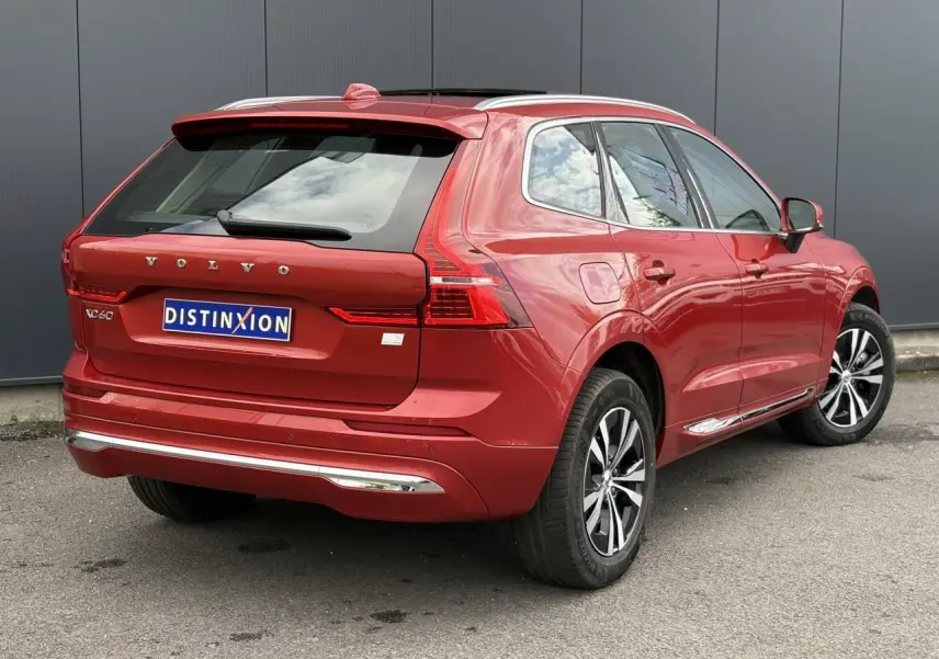 Vue 3/4 arrière droite du Volvo XC60 rouge Fusion avec jantes alliage et contour de vitres chromé.