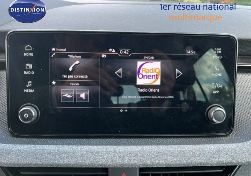 Écran tactile central de la Skoda Scala 2025 affichant la radio Radio Orient, entouré de commandes et finition gris métallique.