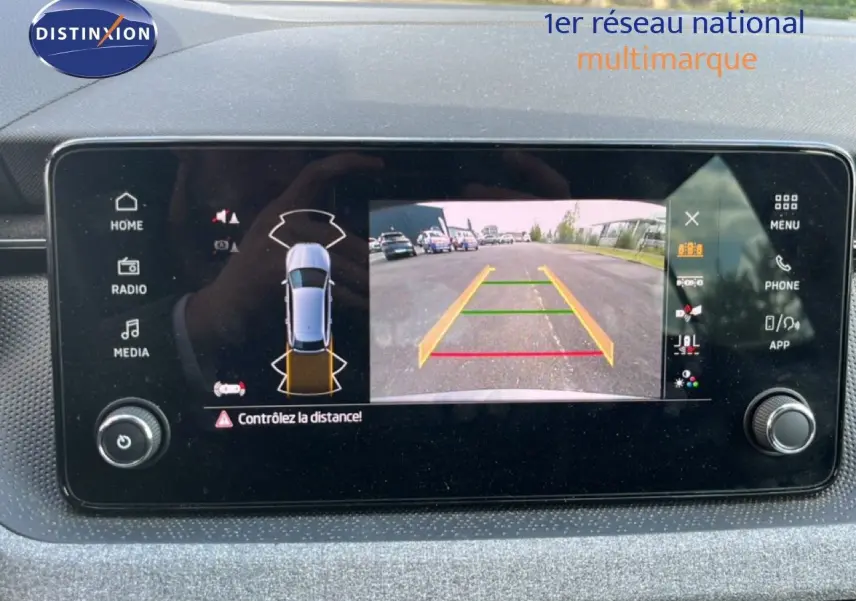 Écran tactile intérieur montrant la caméra de recul et l’alerte de distance d’une Skoda Scala gris magnétique.