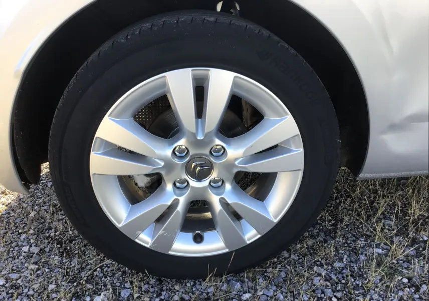 Gros plan sur la roue avant droite d'une Citroën DS3 gris clair métal avec jante alliage 16 pouces et logo Citroën central.