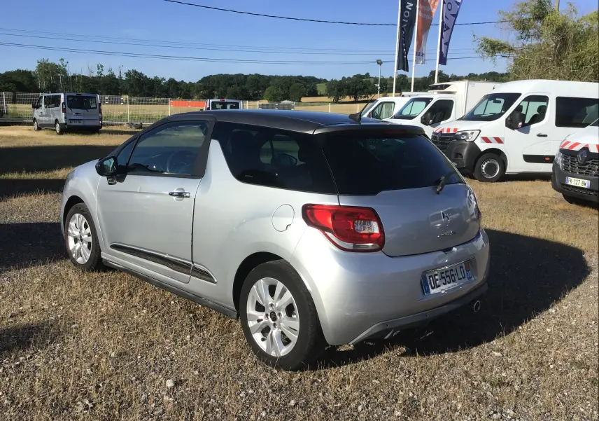 Citroën DS3 gris clair métal vue 3/4 arrière droit, toit noir contrasté et jantes alliage 16 pouces.