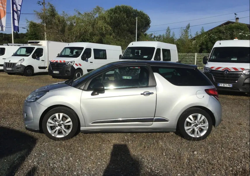 Profil droit d'une Citroën DS3 gris clair métal de 2013, avec toit noir et jantes alliage 16 pouces visibles.