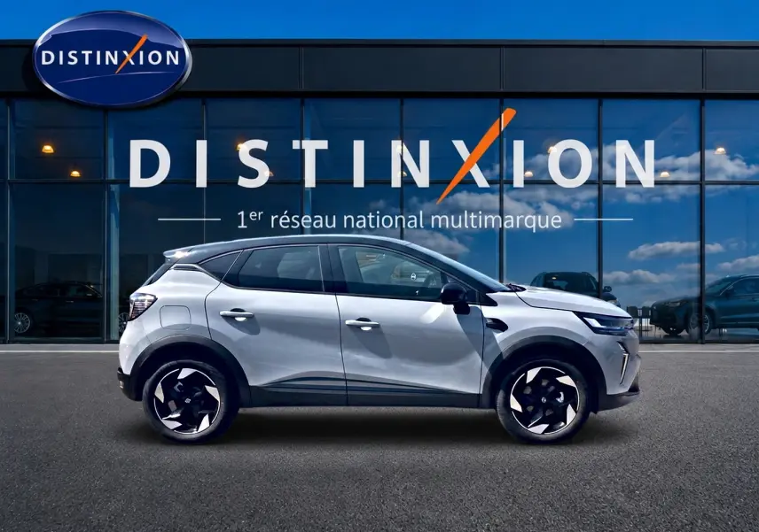 Profil droit du Renault Captur 2026 couleur Rafale avec toit noir et jantes alu noires devant un showroom Distinxion.