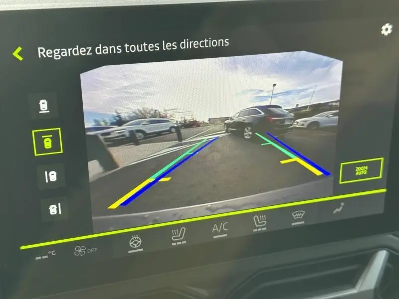 Vue caméra de recul du Dacia Duster 2025 noir nacré, montrant l’arrière droit en stationnement avec lignes d’aide au parking colorées.