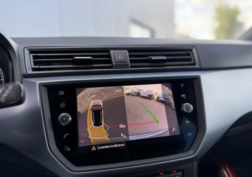 Écran tactile central affichant la caméra de recul et l'aide au stationnement du SEAT Arona gris magnétique, vue intérieure.