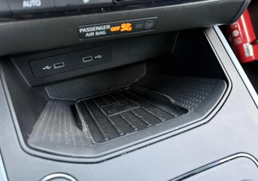 Gros plan sur la console centrale noire du SEAT Arona 2020, montrant les ports USB et la zone de recharge sans fil.