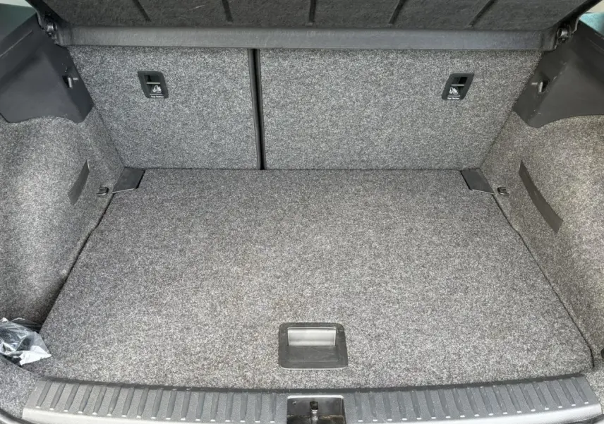 Coffre ouvert d'une SEAT Arona TSI 110 DSG Style 2020, vue intérieure avec revêtement gris et plancher plat.