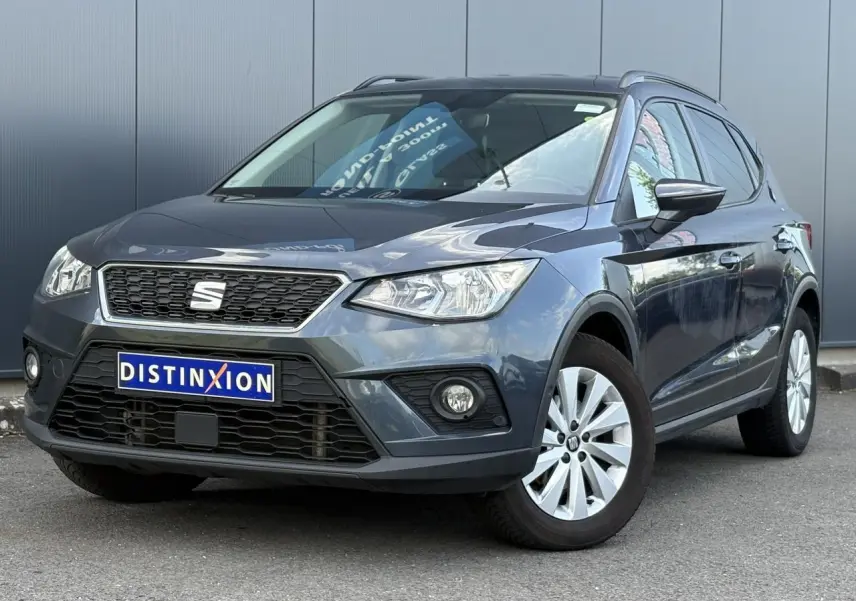 SEAT Arona gris magnétique en 3/4 avant droit, avec calandre noire et jantes alliage 16 pouces.