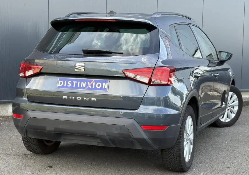 Vue 3/4 arrière droite d'un SEAT Arona gris magnétique avec feux arrière LED et jantes alliage 16 pouces.