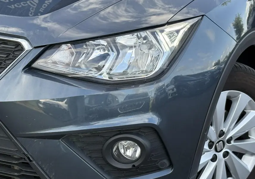 Gros plan sur l'avant droit gris magnétique du SEAT Arona 2020, mettant en valeur le phare et le feu antibrouillard.