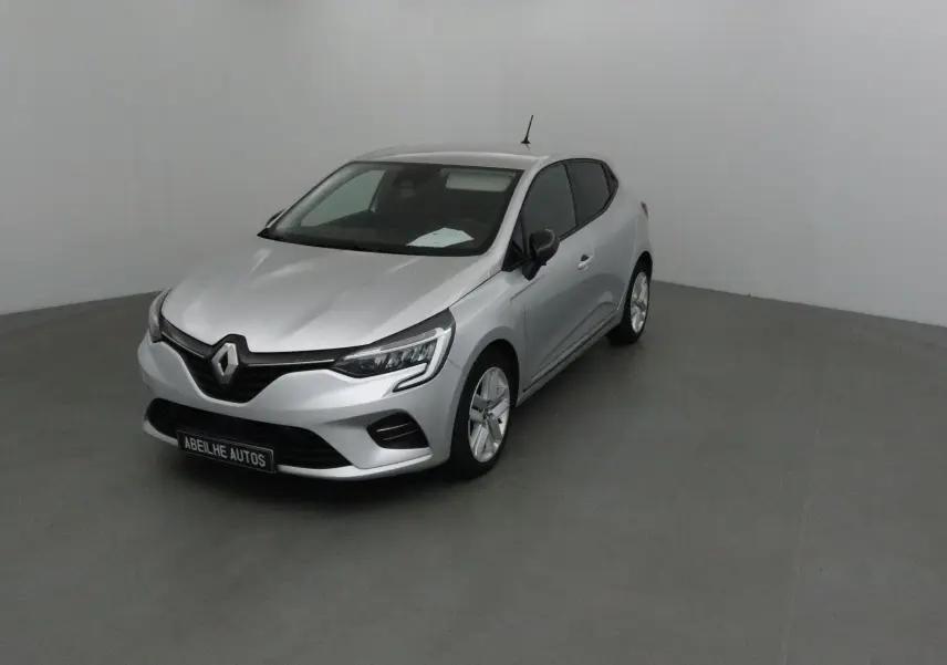 Renault Clio V gris platine vue 3/4 avant droit dans un studio, avec phares LED et calandre noire distinctive.